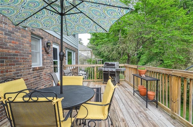 deck with outdoor dining area and a grill