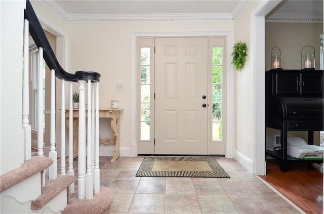 entryway with baseboards, ornamental molding, and stairs