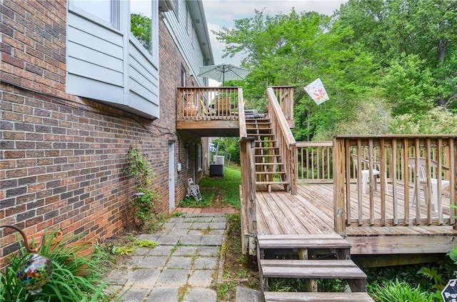 wooden terrace featuring stairs and central AC unit