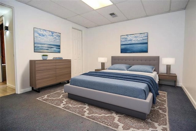bedroom featuring baseboards, carpet flooring, a paneled ceiling, and visible vents