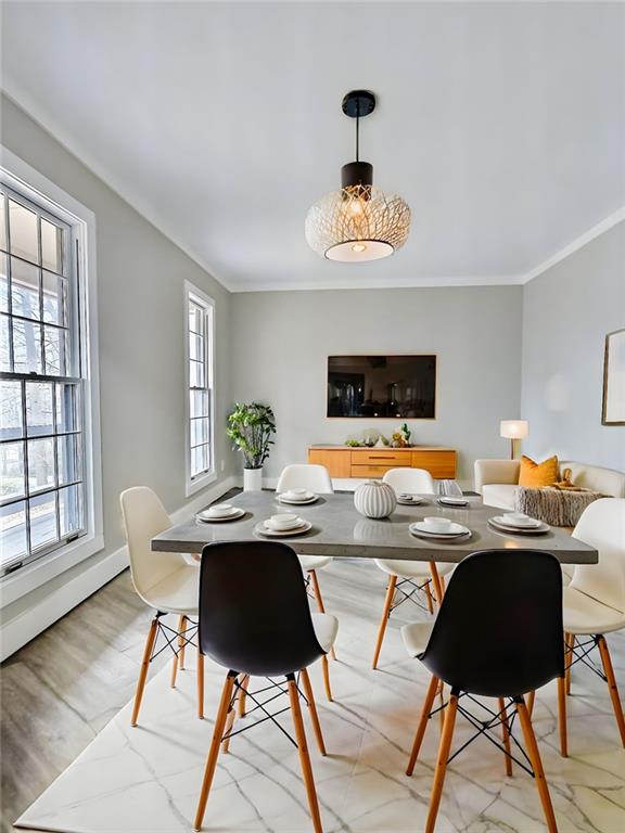 dining area with crown molding and a healthy amount of sunlight