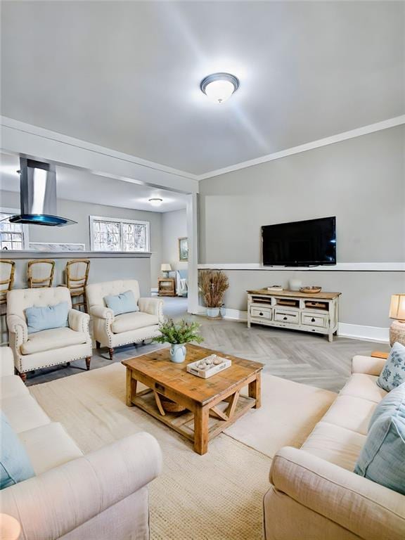 living room with crown molding and light parquet floors