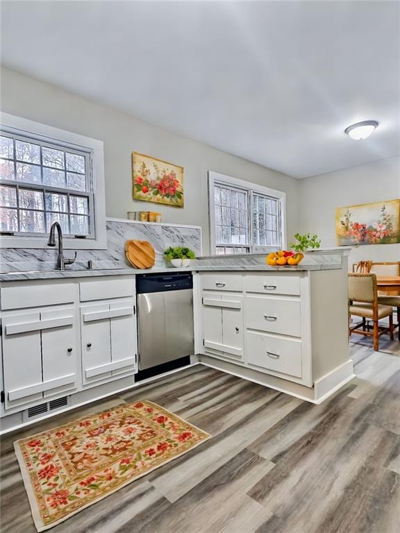 kitchen with hardwood / wood-style flooring, dishwasher, white cabinetry, and kitchen peninsula