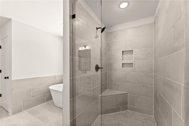418 Brookstone Trl, Dawsonville, GA 30534 - bathroom featuring a shower stall, a soaking tub, tile walls, tile patterned floors, and wainscoting