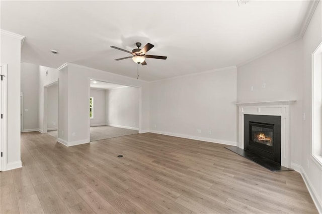418 Brookstone Trl, Dawsonville, GA 30534 - unfurnished living room featuring a ceiling fan, light wood-style floors, a glass covered fireplace, baseboards, and crown molding