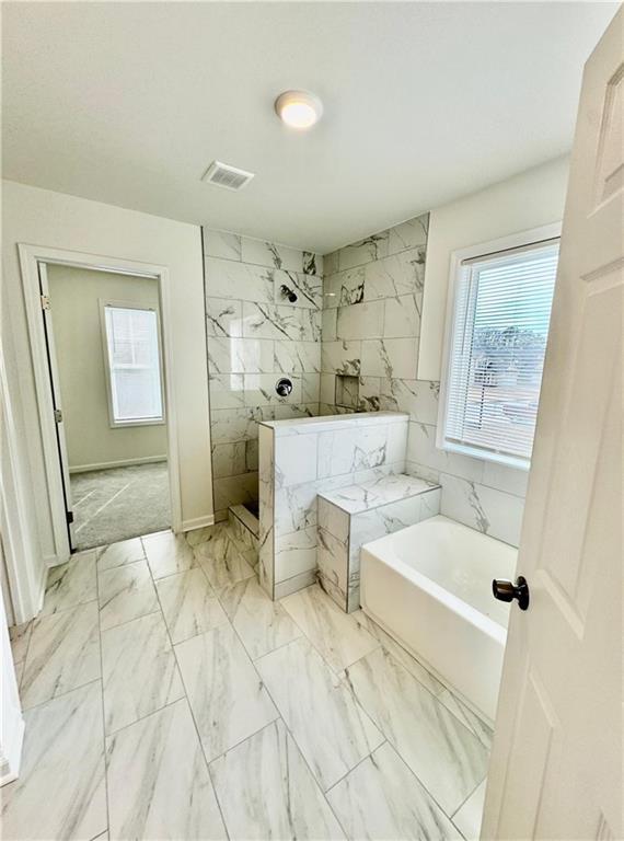 bathroom featuring shower with separate bathtub