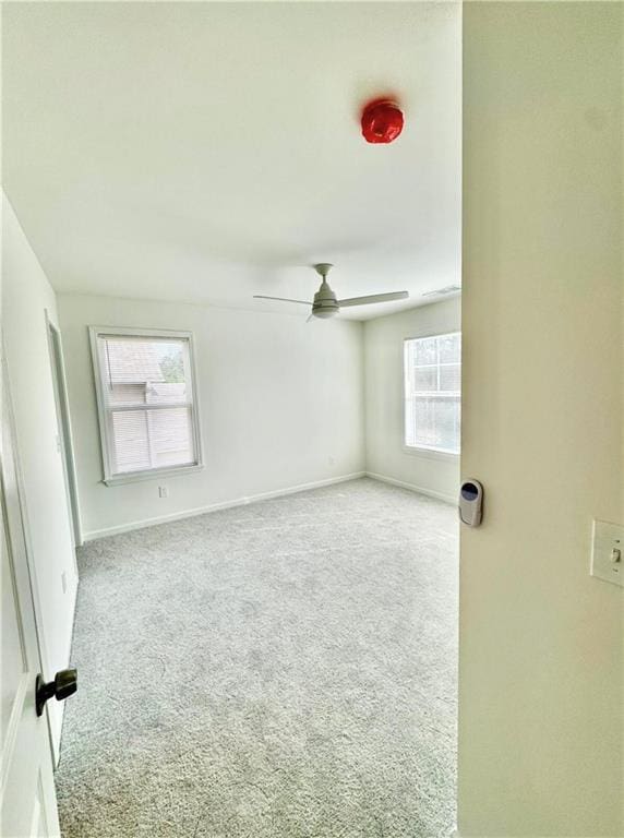 empty room featuring light carpet and ceiling fan