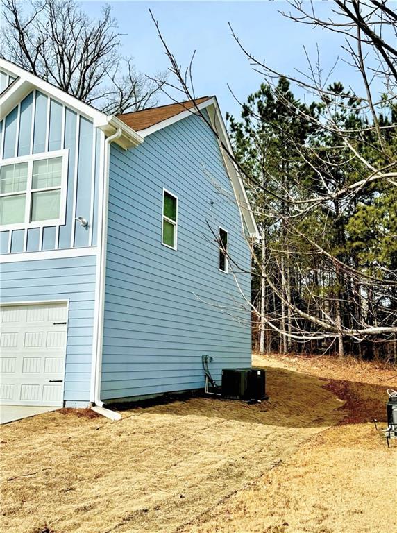 view of property exterior with a garage and central air condition unit