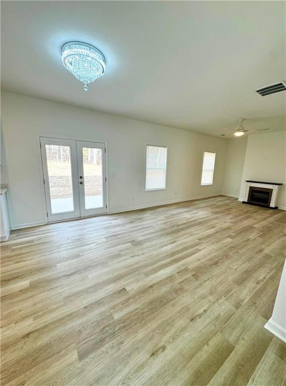 unfurnished living room featuring light hardwood / wood-style flooring and french doors