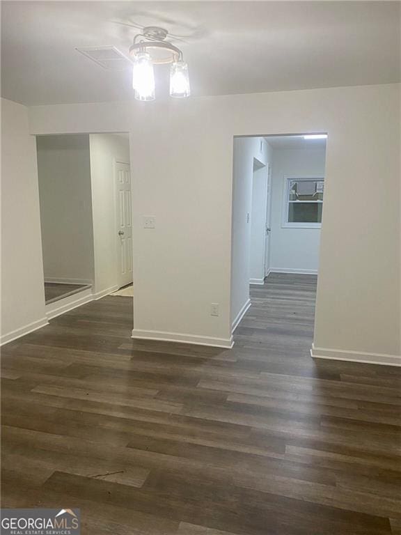 unfurnished room with baseboards, dark wood finished floors, and a ceiling fan
