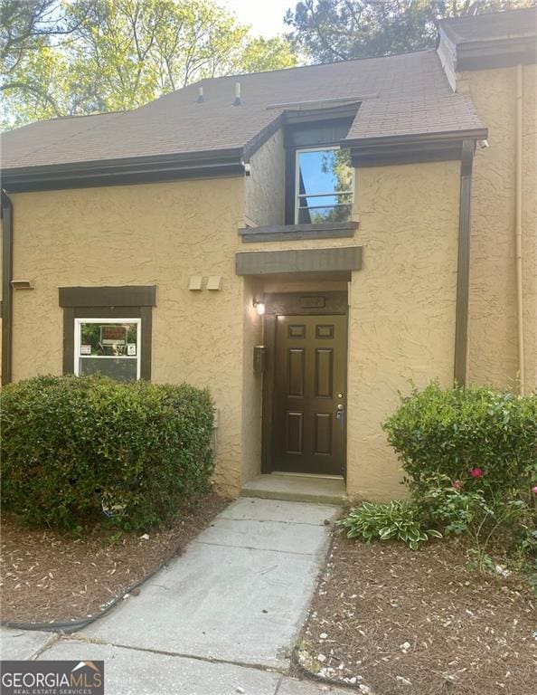entrance to property featuring stucco siding