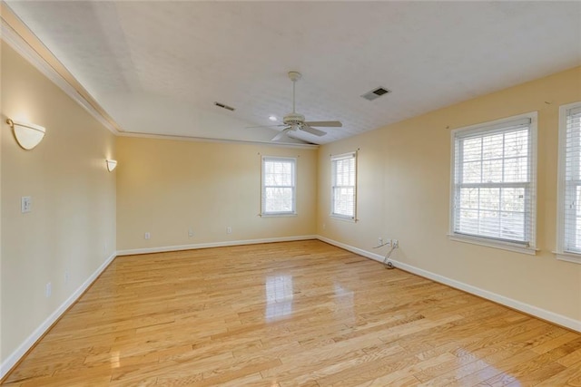 unfurnished room with light wood-type flooring, visible vents, and baseboards