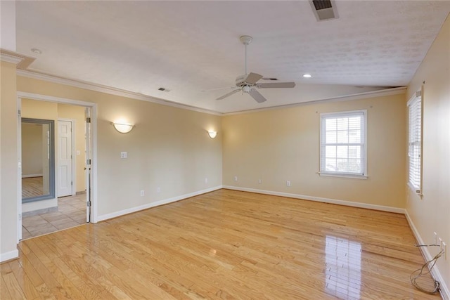 spare room featuring baseboards, light wood-style floors, visible vents, and ornamental molding