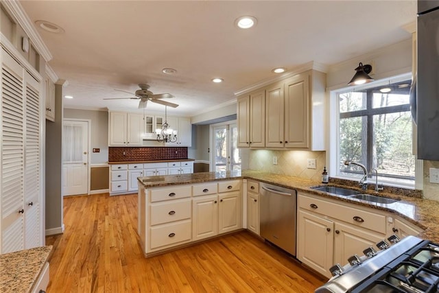 kitchen with ornamental molding, a peninsula, stainless steel appliances, and a sink