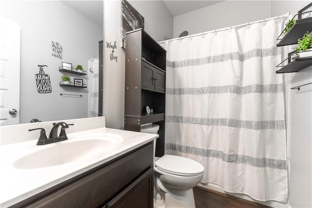 full bathroom with shower / bath combo with shower curtain, hardwood / wood-style floors, toilet, and vanity