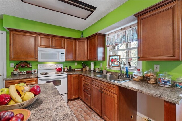 kitchen with sink, light tile patterned floors, and white appliances