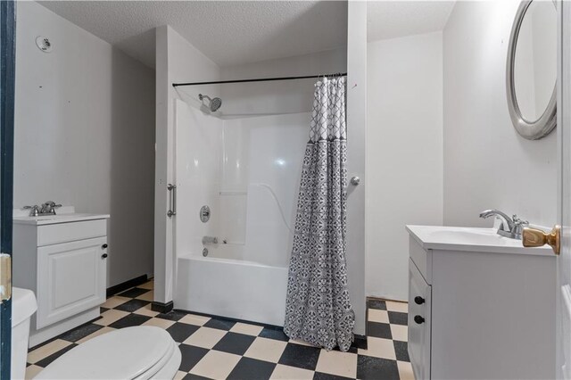 full bathroom featuring vanity, a textured ceiling, shower / tub combo with curtain, and toilet