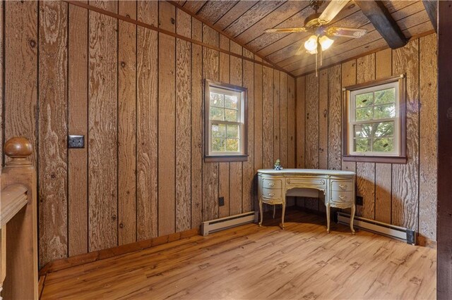 unfurnished office featuring light hardwood / wood-style flooring, vaulted ceiling, a wealth of natural light, and wooden walls