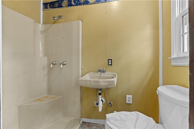 bathroom with toilet, walk in shower, and sink