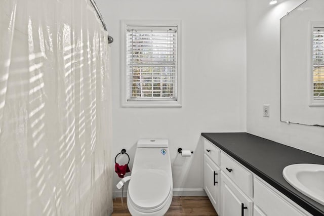 bathroom featuring vanity, hardwood / wood-style flooring, toilet, and a wealth of natural light