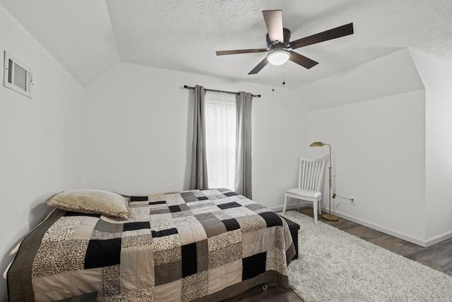 bedroom featuring a textured ceiling, ceiling fan, vaulted ceiling, and hardwood / wood-style flooring