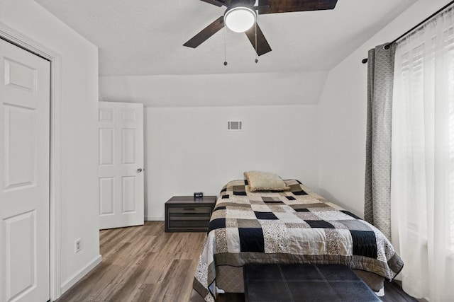 bedroom featuring light hardwood / wood-style flooring, ceiling fan, and lofted ceiling