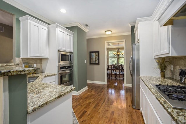 212 Westwind Dr, Newnan, GA 30263 - kitchen with stainless steel appliances, white cabinetry, dark wood finished floors, light stone countertops, and ornamental molding