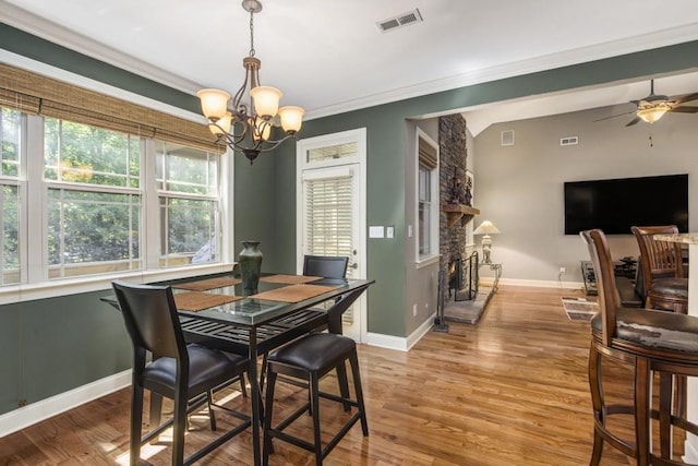 212 Westwind Dr, Newnan, GA 30263 - dining room featuring a chandelier, light wood-type flooring, ceiling fan, ornamental molding, and a fireplace
