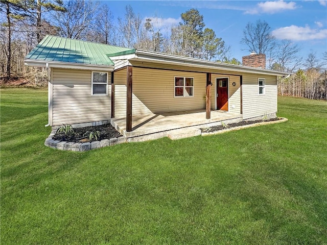 rear view of property with a patio and a lawn