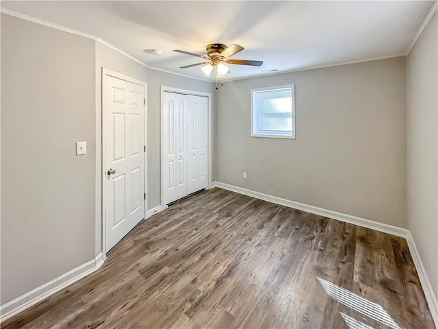 unfurnished bedroom featuring ceiling fan, ornamental molding, and dark hardwood / wood-style flooring