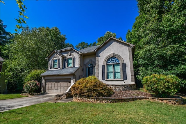 view of front of property featuring driveway, a front yard, a garage, and stucco siding