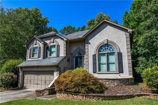 view of front of house with a garage, concrete driveway, a shingled roof, and stucco siding