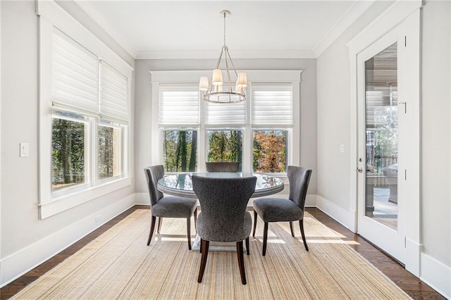 dining room with plenty of natural light, crown molding, and wood finished floors