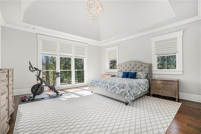 bedroom with a raised ceiling, visible vents, a towering ceiling, wood finished floors, and baseboards