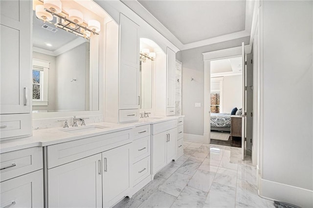 full bathroom featuring double vanity, baseboards, marble finish floor, crown molding, and a sink