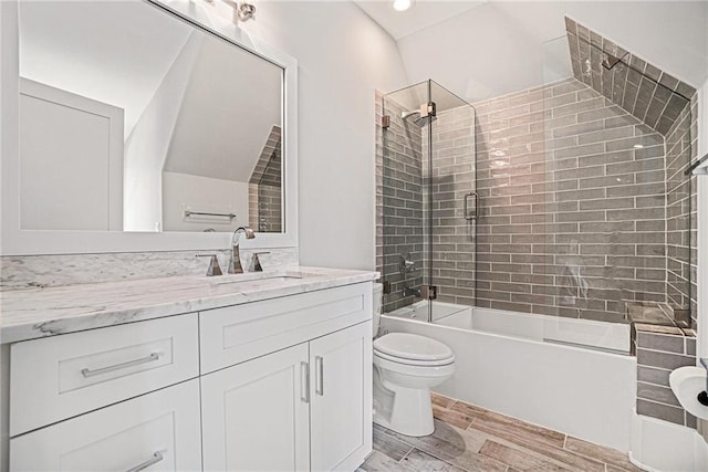 bathroom with vanity, wood finish floors, shower / tub combination, and toilet