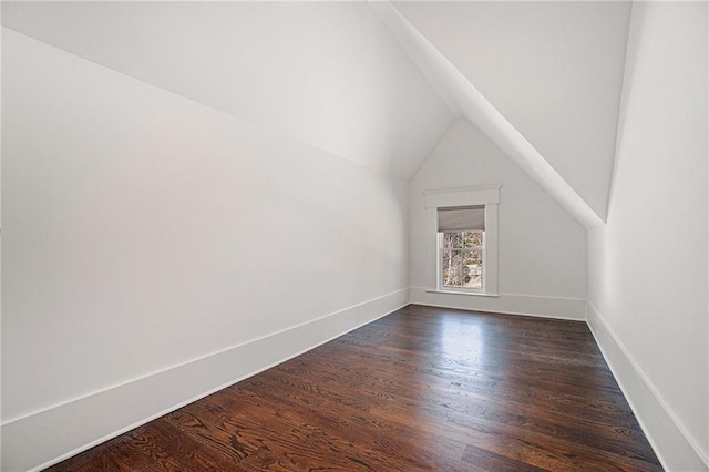 bonus room featuring dark wood-style flooring, vaulted ceiling, and baseboards