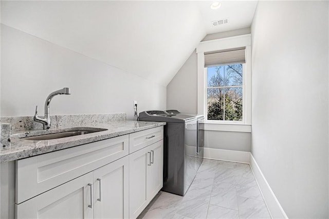 washroom with cabinet space, baseboards, visible vents, separate washer and dryer, and a sink