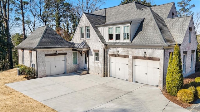 view of front facade featuring a shingled roof, concrete driveway, brick siding, and an attached garage