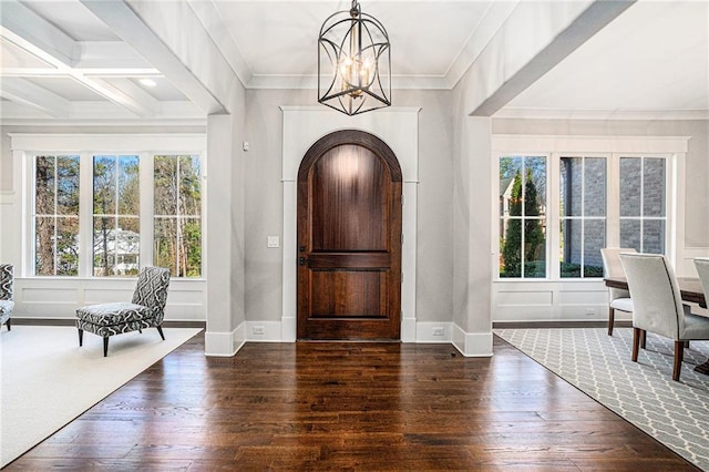 entryway with ornamental molding, a decorative wall, and hardwood / wood-style floors