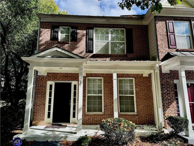 view of front facade featuring covered porch and brick siding