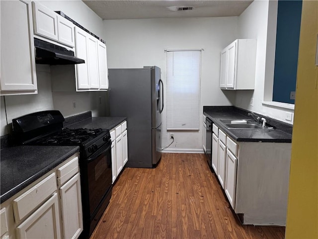 kitchen featuring a sink, black range with gas stovetop, dark wood finished floors, under cabinet range hood, and fridge with ice dispenser