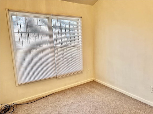 carpeted empty room with baseboards