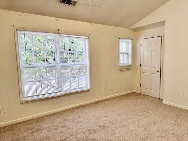 spare room featuring lofted ceiling, baseboards, visible vents, and carpet floors