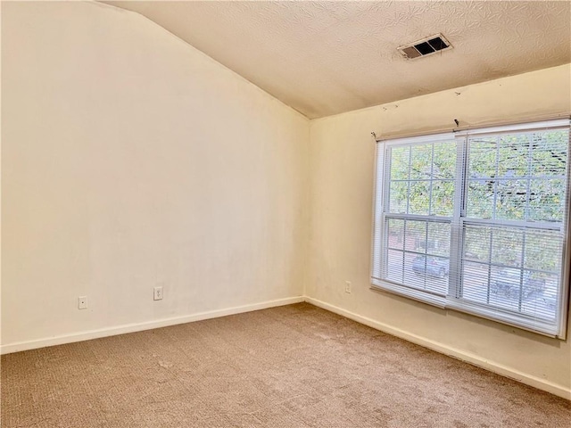 unfurnished room featuring visible vents, baseboards, lofted ceiling, and light carpet