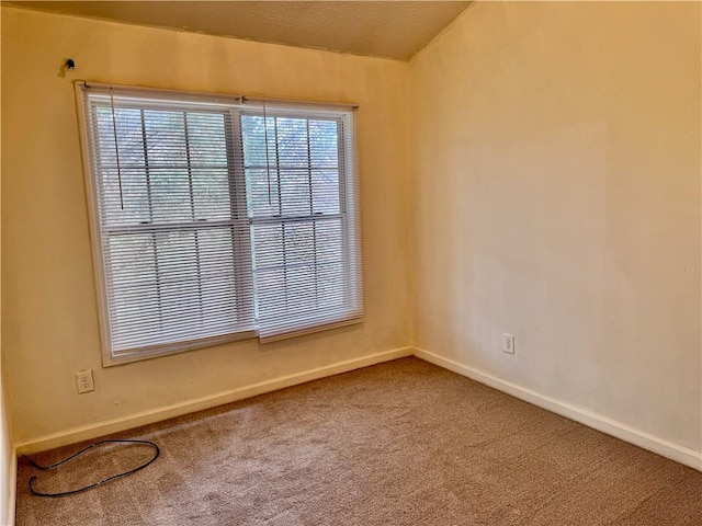 unfurnished room featuring carpet and baseboards