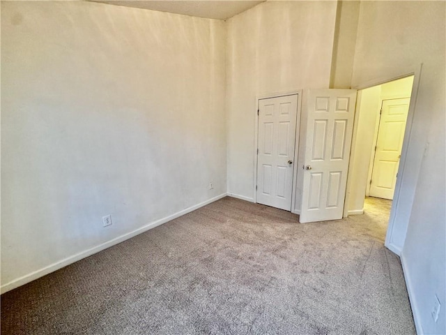 carpeted spare room featuring baseboards