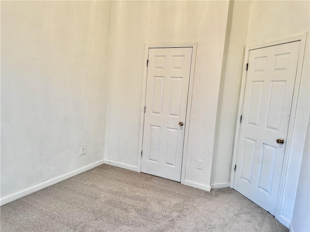 unfurnished bedroom with carpet flooring and baseboards