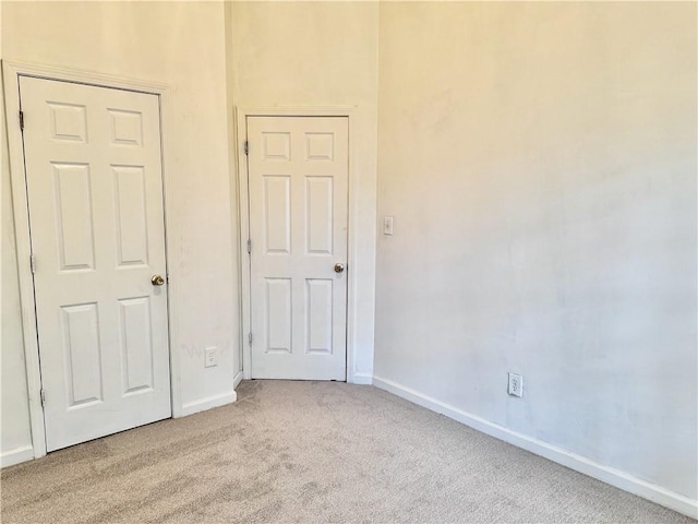 unfurnished bedroom featuring carpet floors and baseboards
