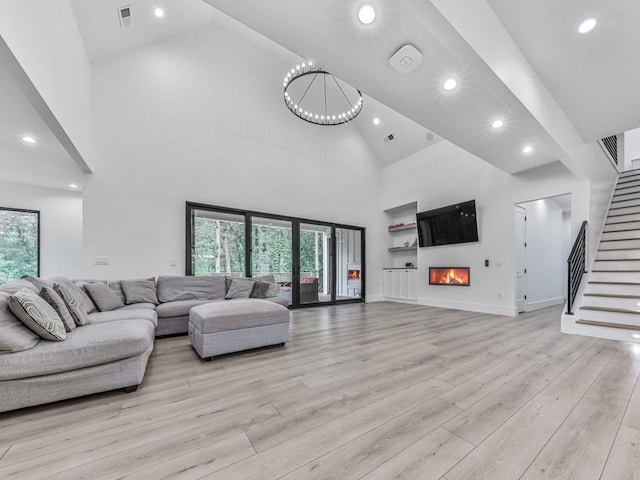 106 Belmont Dr, Canton, GA 30115 - living area with recessed lighting, high vaulted ceiling, light wood finished floors, stairway, and a warm lit fireplace